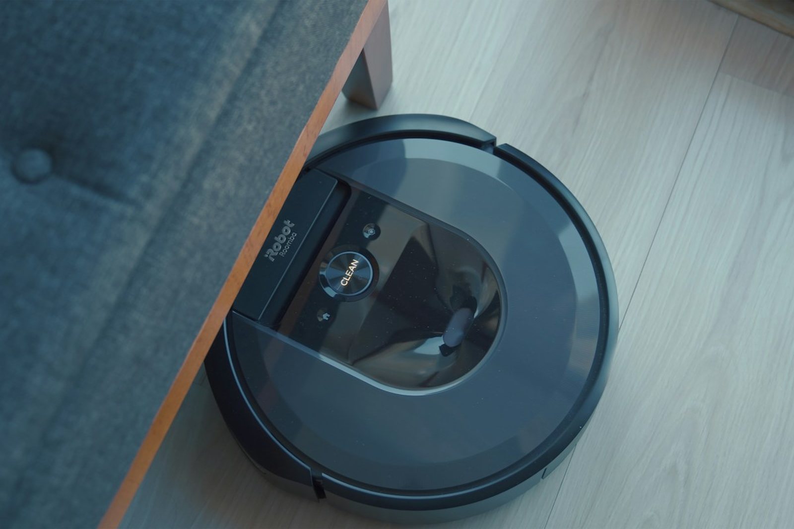 a robotic vacuum is on the floor next to a couch